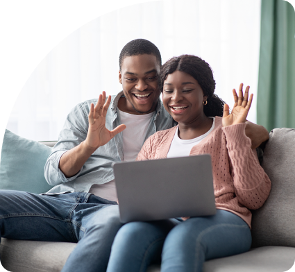 Couple celebrating after booking their Virtual OBGYN appointment on a laptop computer